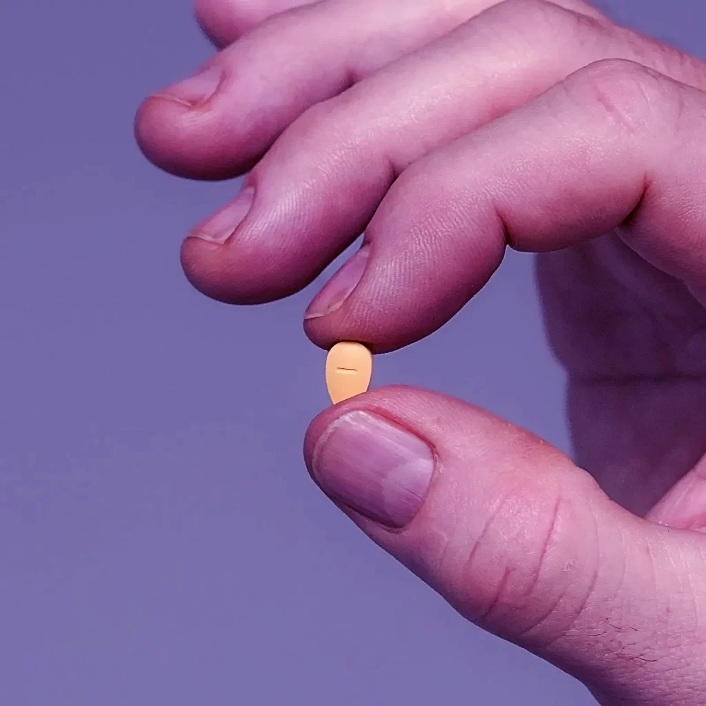 Tadalafil Dosierungsleitfaden 1 Hand hält eine Tadalafil-Tablette