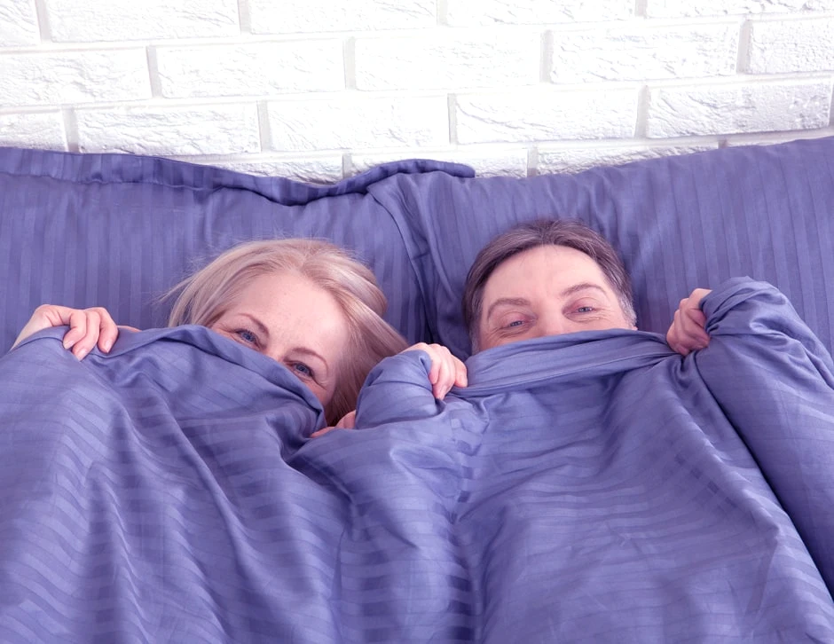 Macht Cialis, dass man länger durchhält? 1 Bild einer Frau und eines Mannes im Bett lächelnd